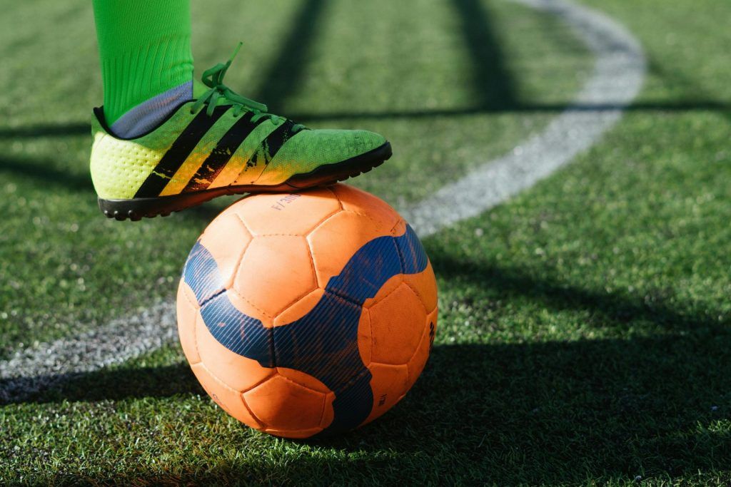 jugador de futbol base con balon en los pies